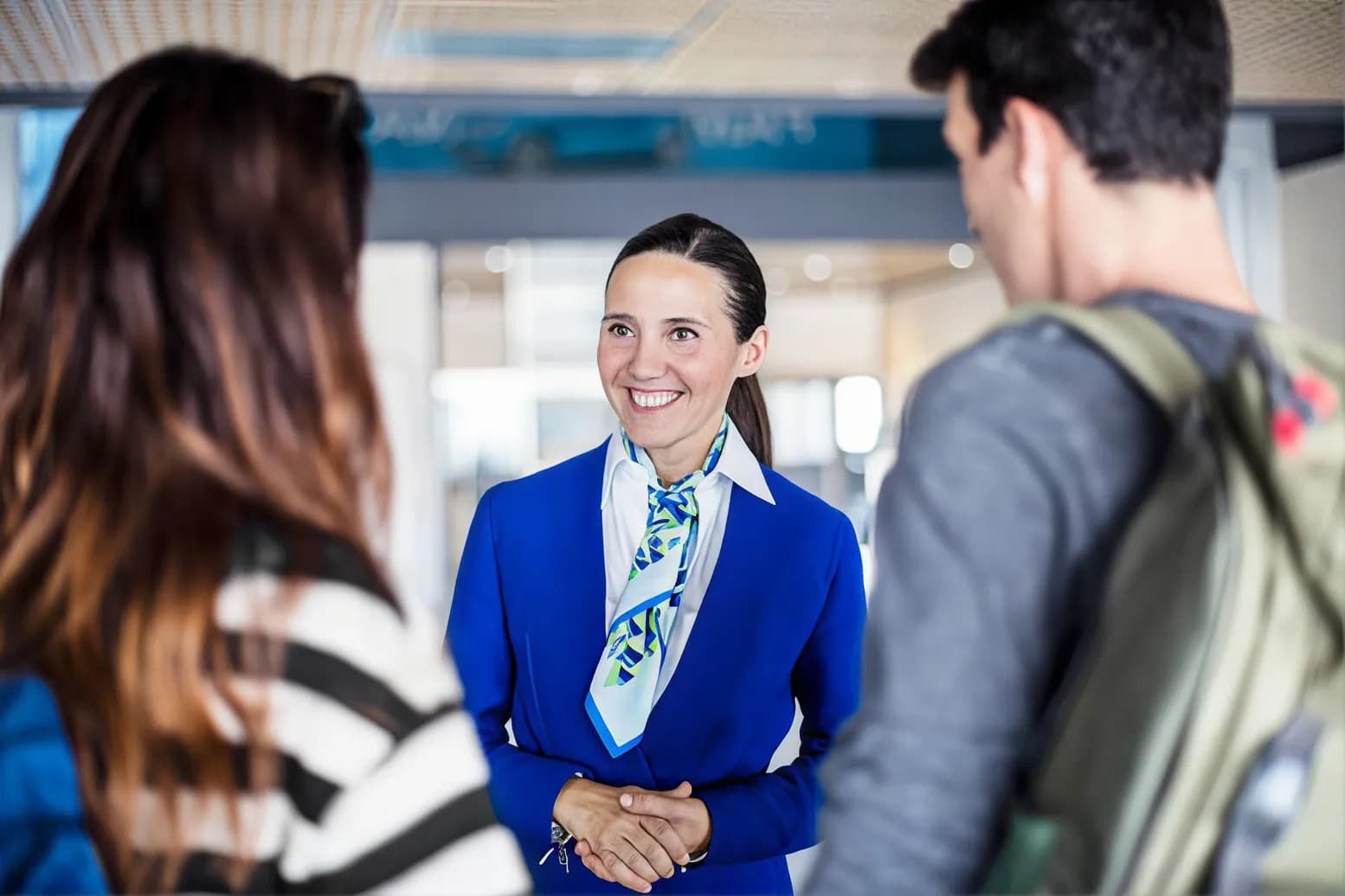 A uniformed greeter welcoming a traveler in a terminal