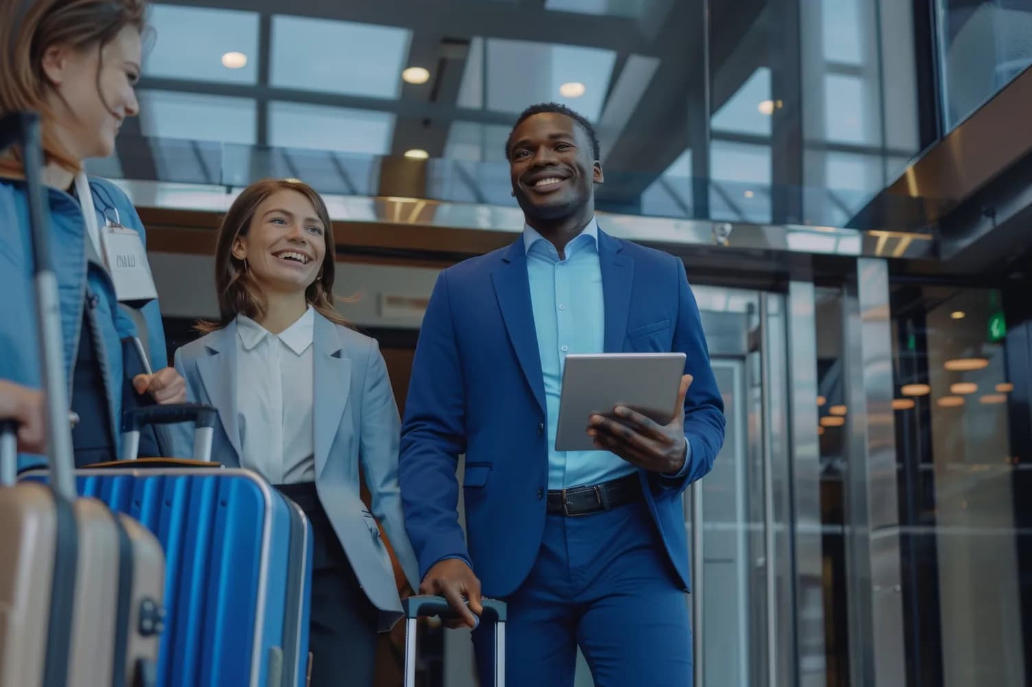 Two business travelers walking through an airport with luggage