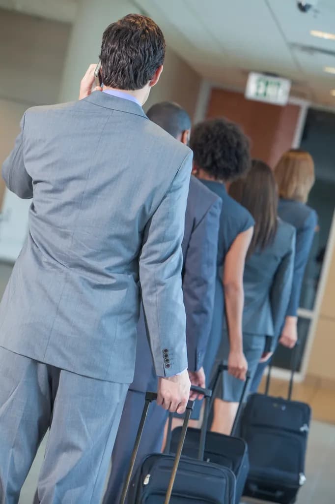 Travelers queuing with luggage at a departure counter