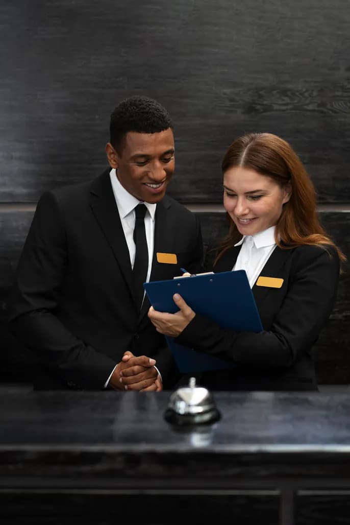 Two representatives reviewing service details at a reception desk