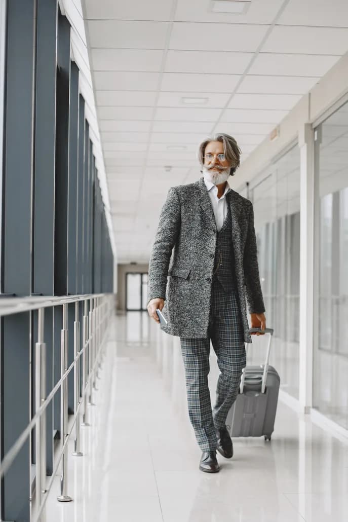 A business traveler in a grey coat holding a passport at the airport