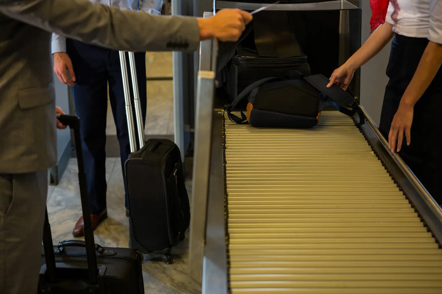 A traveler lifting a bag onto the check-in belt