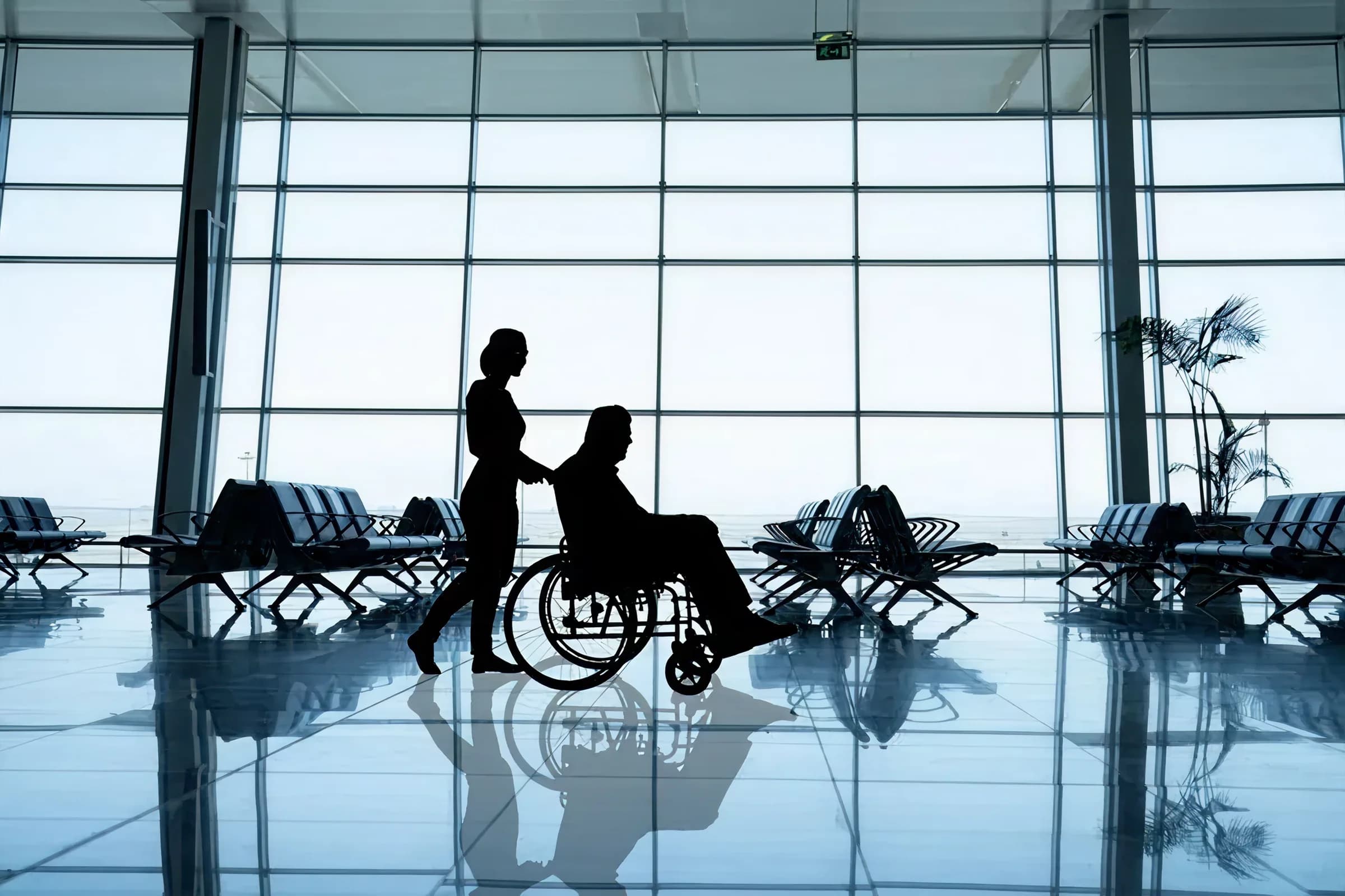 An airport attendant assisting a traveler using a wheelchair