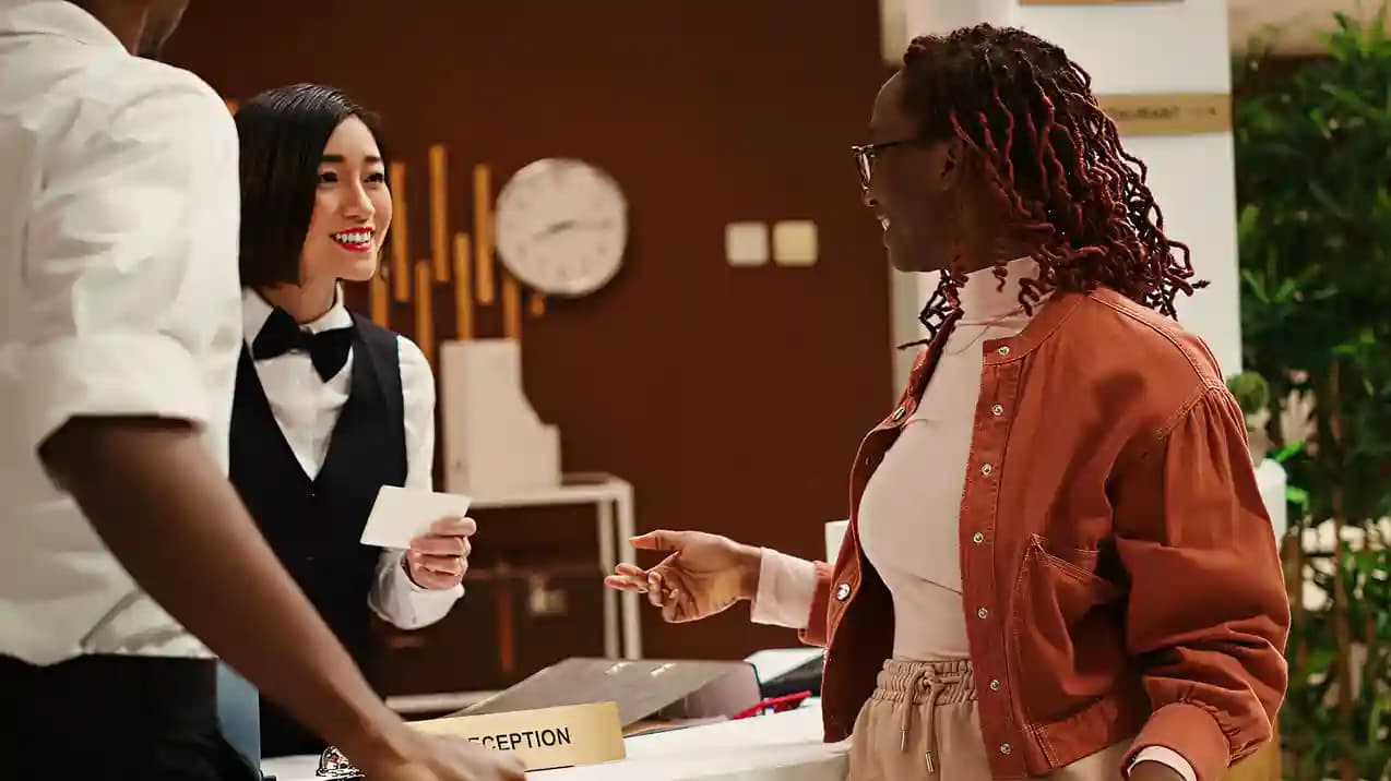 A guest being handed a card at a lounge reception desk